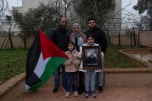 From top left, Hafeth, 40, father, Mona, 36, mother, Amir, 22, brother and from down left, Yaffa, 7, and Rabea, 8, sisters, pose with a framed photo and name, of their slain family member 17-year-old Tawfic Abdel Jabbar, a teenager from Louisiana who was fatally shot last week, at the family's Palestinian home village, Al-Mazra'a ash-Sharqiya, West Bank, Tuesday, Jan. 23, 2024. (AP)