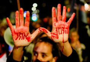 A-demonstrator-holds-up-their-hands-painted-in-red-with-the-message-Time-is-running-out.