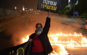 Protestors on the blocked Ayalon Highway in Tel Aviv calling for the immediate release of the hostages held in Gaza, January 18, 2024. (Lior Segev)